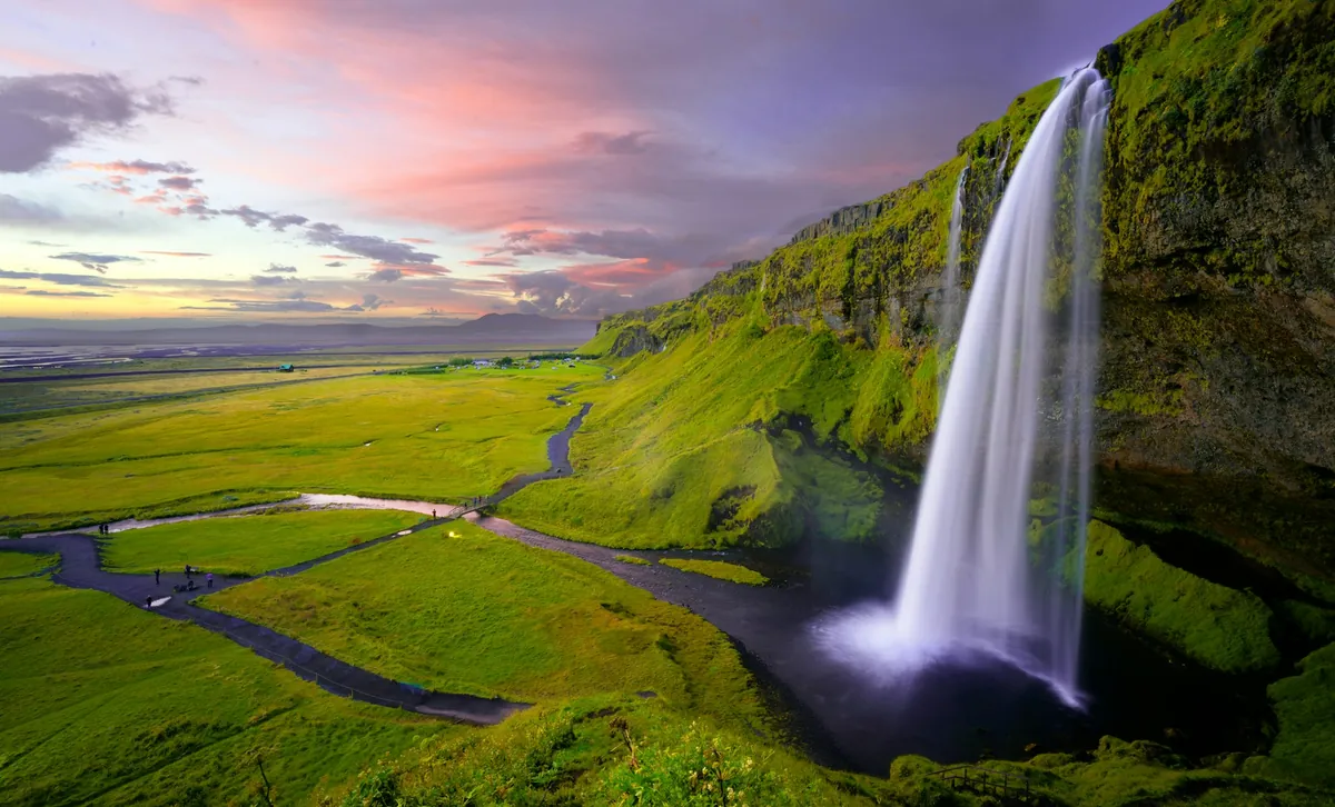 Icelandic waterfall framed by a green landscape